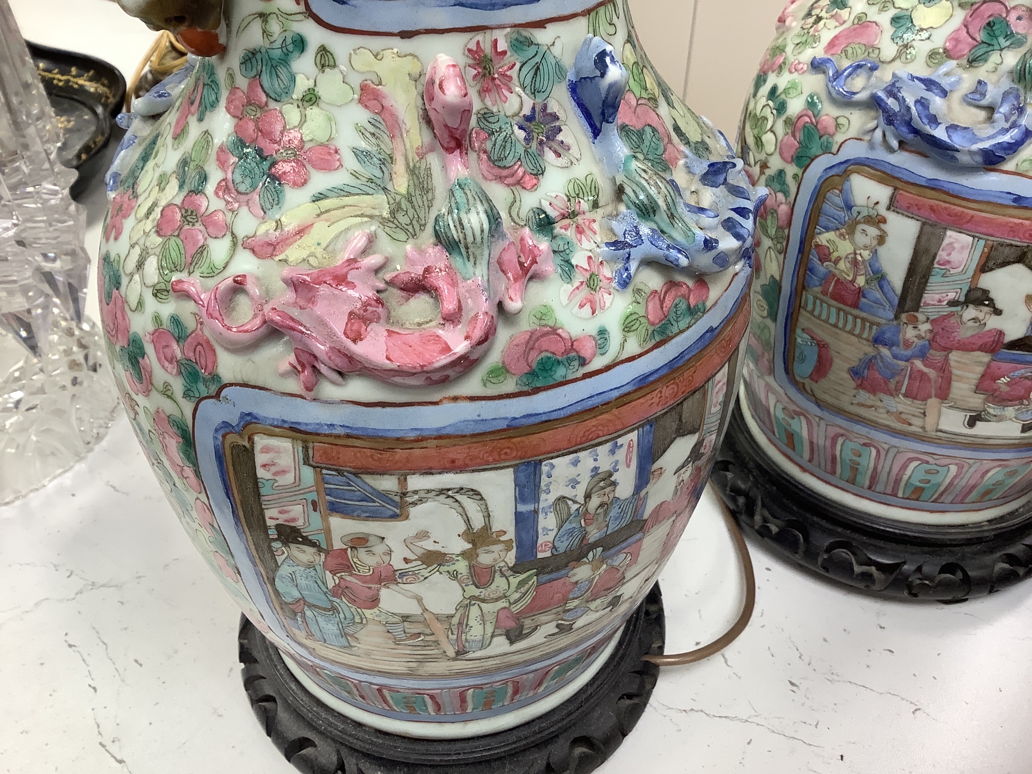 A pair of 19th century Chinese famille rose baluster vases, fitted as table lamps, on hardwood stands